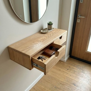 Può includere: Un set di tre tazze in ceramica con finitura opaca e macchiettata. Le tazze sono nei toni del crema, grigio chiaro e grigio scuro. Ogni tazza ha un design semplice e minimalista.