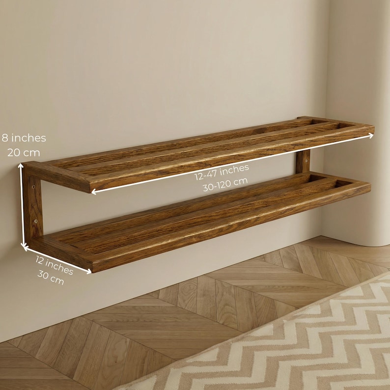 May include: A two-tiered wooden shelf, stained in a warm brown hue, mounted on a wall. The top shelf measures 12-47 inches (30-120 cm) in length, while the lower shelf is 12 inches (30 cm) wide. The shelf is 8 inches (20 cm) high.