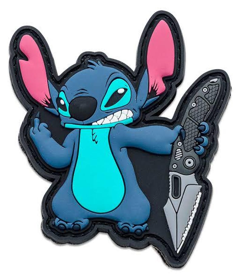 May include: A blue cartoon character patch with large pink ears and a turquoise belly, holding a gray knife. The character has a black nose and is set against a black background with a black border.