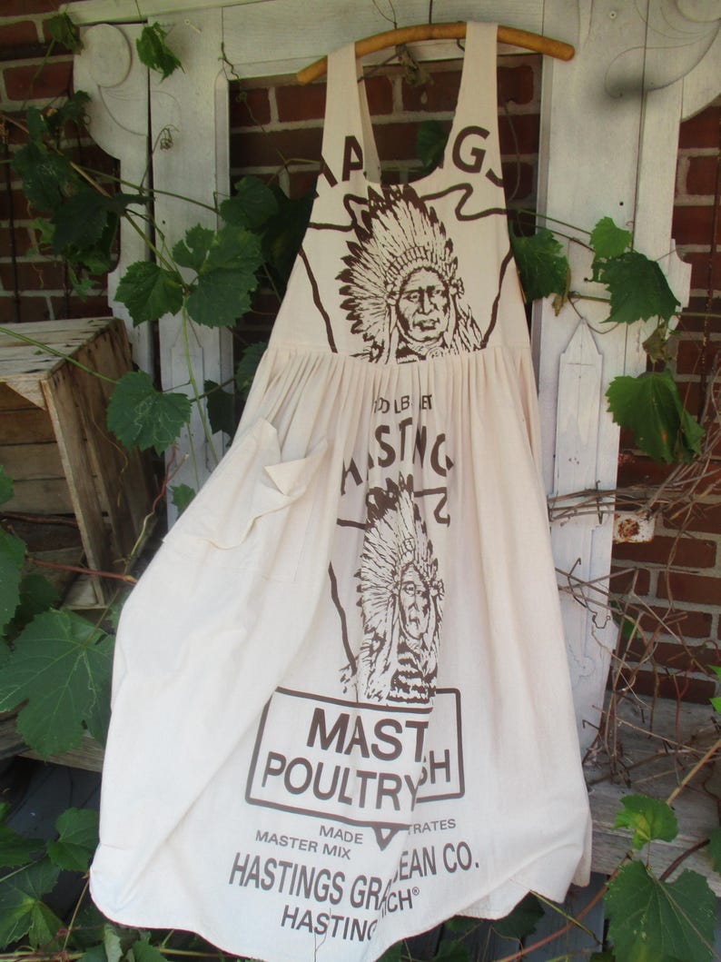 May include: A white cotton apron with a brown print of a Native American chief and the text "MASTH POULTRY" and "HASTINGS GRAIN CO."