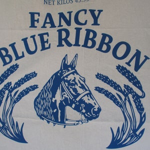 May include: Blue and white logo with the text "Fancy Blue Ribbon" and a stylized image of a horse's head with wheat stalks on either side.