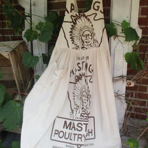 May include: A white cotton apron with a brown print of a Native American chief and the text "MASTH POULTRY" and "HASTINGS GRAIN CO."