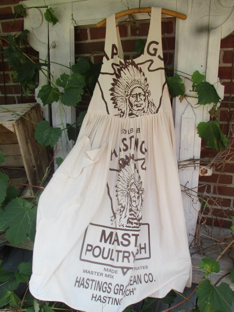 May include: A white cotton apron with a brown print of a Native American chief and the text "MASTH POULTRY" and "HASTINGS GRAIN CO."