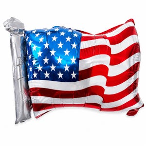 May include: A large, shiny balloon shaped like the American flag. The balloon features a blue field with white stars and red and white stripes. A silver-colored section represents the balloon's handle.