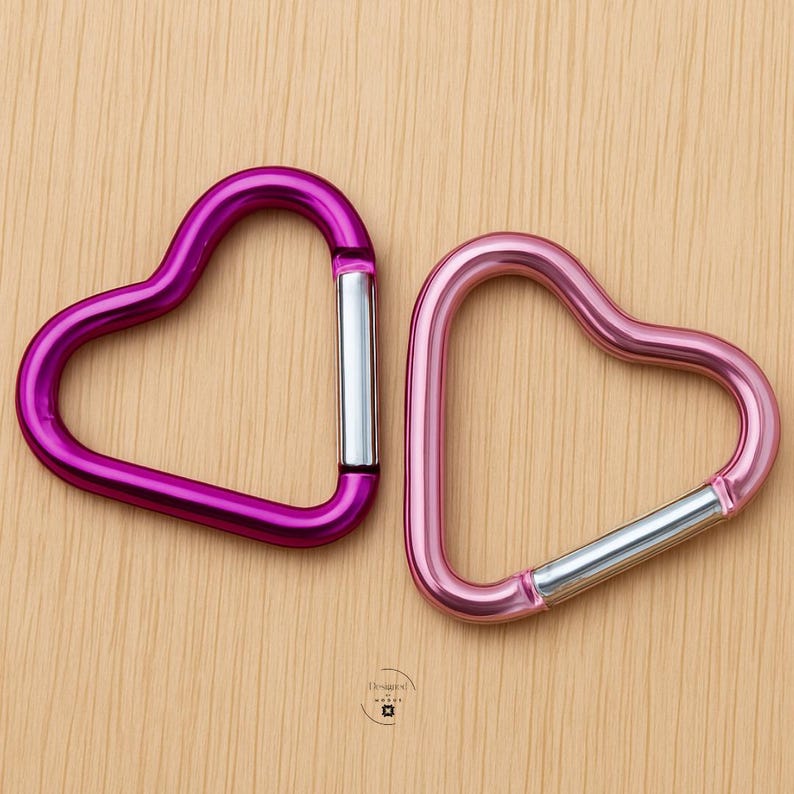Pink heart shaped carabiner clips on wooden background