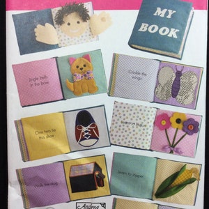 May include: A Simplicity 3709 sewing pattern envelope for a fabric activity book. The cover displays various pages featuring interactive elements like a plush face, a dog, a butterfly, a shoe, flowers with buttons, a doghouse, corn, and a bird in a nest.