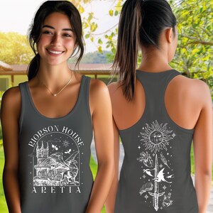 A woman wearing a gray tank top with a graphic design on the front and back.