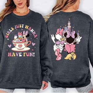 A gray sweatshirt with a graphic design featuring Minnie Mouse and Mickey Mouse in a cup, along with the text "Girls just wanna have fun!"