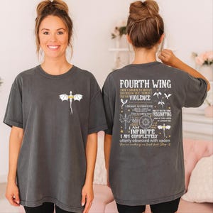 A woman wearing a gray t-shirt with a dragon design and text printed on the back.