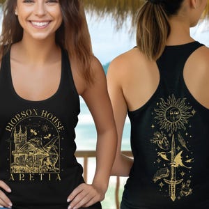A smiling woman wearing a black tank top with a graphic design on the front and a back design on the back.