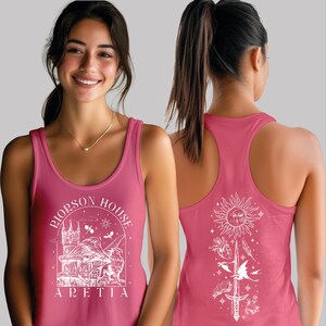 A woman wearing a pink tank top with a graphic design on the front and back.