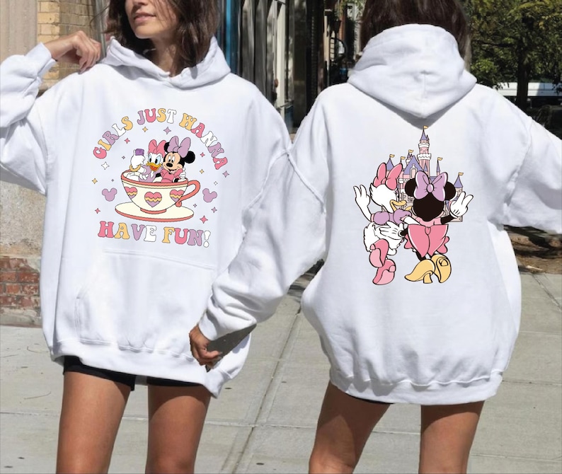 A woman wearing a white hoodie with a graphic of Minnie Mouse and a castle on the back.