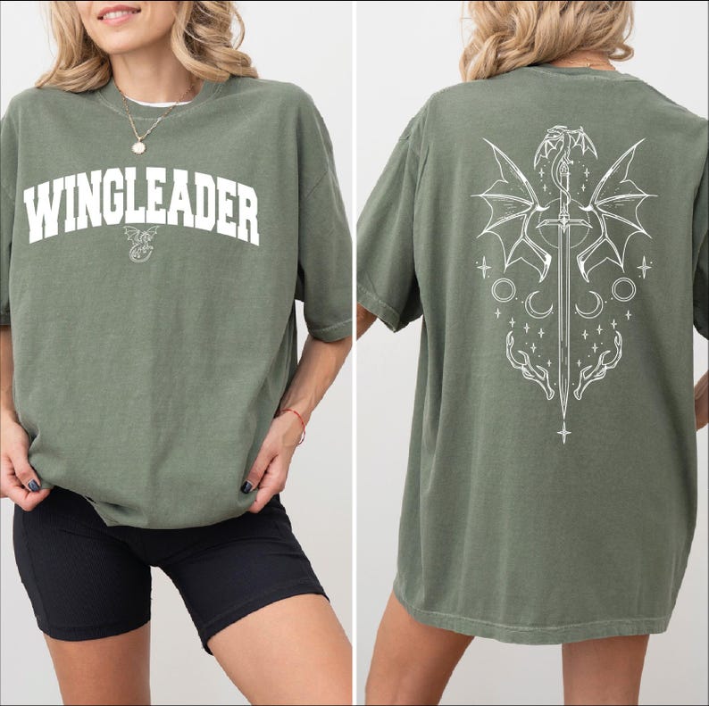 A woman wearing a green t-shirt with the text "WINGLEADER" printed on it, along with a graphic design featuring a dragon and stars.