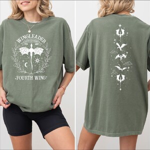 A woman wearing a green t-shirt with a graphic design on the front and back.