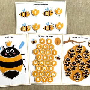 K&ouml;nnte beinhalten: Drei druckbare Arbeitsbl&auml;tter mit Bienen-Motiv. Das erste Blatt zeigt eine Biene mit Krone und Fl&uuml;geln, das zweite Blatt zeigt eine Wabe mit den Buchstaben A-Z und das dritte Blatt zeigt eine Wabe mit den Zahlen 1-12.