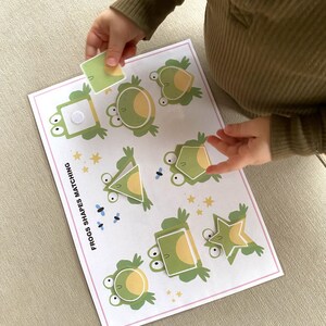 K&ouml;nnte beinhalten: Ein Lernspiel f&uuml;r Kinder mit Fr&ouml;schen in verschiedenen Formen. Das Spiel enth&auml;lt eine Vielzahl von Formen, darunter einen Kreis, ein Quadrat, ein Dreieck und einen Stern. Das Spiel hei&szlig;t "Frogs Shapes Matching".
