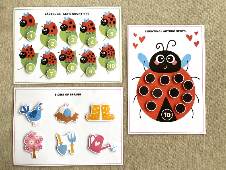 K&ouml;nnte beinhalten: Ein Satz von drei druckbaren Lernspielkarten f&uuml;r Kinder mit Marienk&auml;fern. Die erste Karte zeigt Marienk&auml;fer mit den Zahlen 1-10. Die zweite Karte zeigt einen Marienk&auml;fer mit 10 Punkten zum Z&auml;hlen. Die dritte Karte zeigt Bilder von Fr&uuml;hlingszeichen, darunter einen Vogel, ein Nest mit Eiern, Stiefel, eine Blume, eine Schaufel und eine Gie&szlig;kanne.