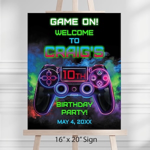 Può includere: Un cartello nero con una grafica di controller di videogiochi in stile neon. Il testo include "GAME ON!" e "CRAIG'S 10TH BIRTHDAY PARTY!". Il cartello misura 40,6 cm per 50,8 cm.