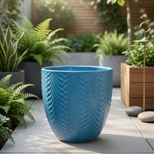 May include: A bright blue ceramic plant pot featuring a raised, vertical herringbone or leaf-like texture pattern across its exterior surface. The vessel has a wide, circular opening and a smooth, glossy finish that reflects light.