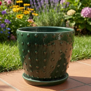 May include: A deep forest green ceramic plant pot with a glossy finish and a raised dot texture across the exterior surface. The cylindrical vessel features a matching circular saucer base and a wide, open top rim for holding various plants.