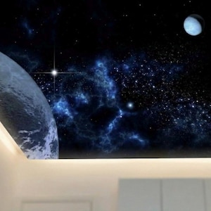 May include: A ceiling mural depicting a vibrant night sky scene. The artwork features a large planet, a crescent moon, and a multitude of stars and nebulas in shades of blue and white against a dark background. The mural is framed by a white border.