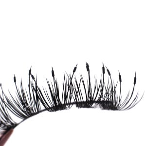May include: Black false eyelashes with a unique design. The lashes feature long, thin, curved strands with small, dark accents at the tips, resembling blades of grass or reeds. The lashes are set against a white background.