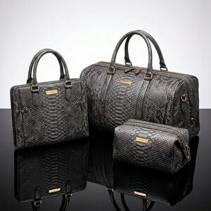 May include: A set of three matching gray snake-skin textured bags. The set includes a small square handbag, a large duffel bag, and a rectangular cosmetic bag. Each bag has gold-colored hardware and a rectangular gold label.