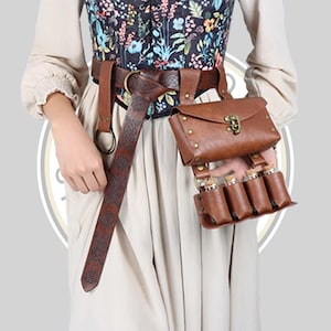May include: A brown leather belt featuring an embossed pattern, a large metal ring, and an attached pouch with a brass-colored clasp. Below the pouch, a leather holder contains four small glass vials with cork stoppers, worn over a floral corset.