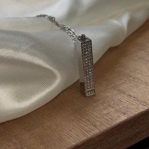 Könnte beinhalten: Eine weiße Keramik-Tasse mit schwarzem Henkel und dem Text "But First, Coffee" in schwarzer, fetter Schrift. Die Tasse steht auf einer Holzoberfläche.