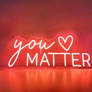 May include: Neon sign with the words "you" and a heart symbol, followed by the word "matter". The sign is white and glows pink.