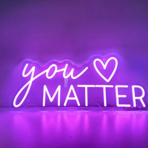 May include: A neon sign with a purple glow that reads "you &hearts; matter".