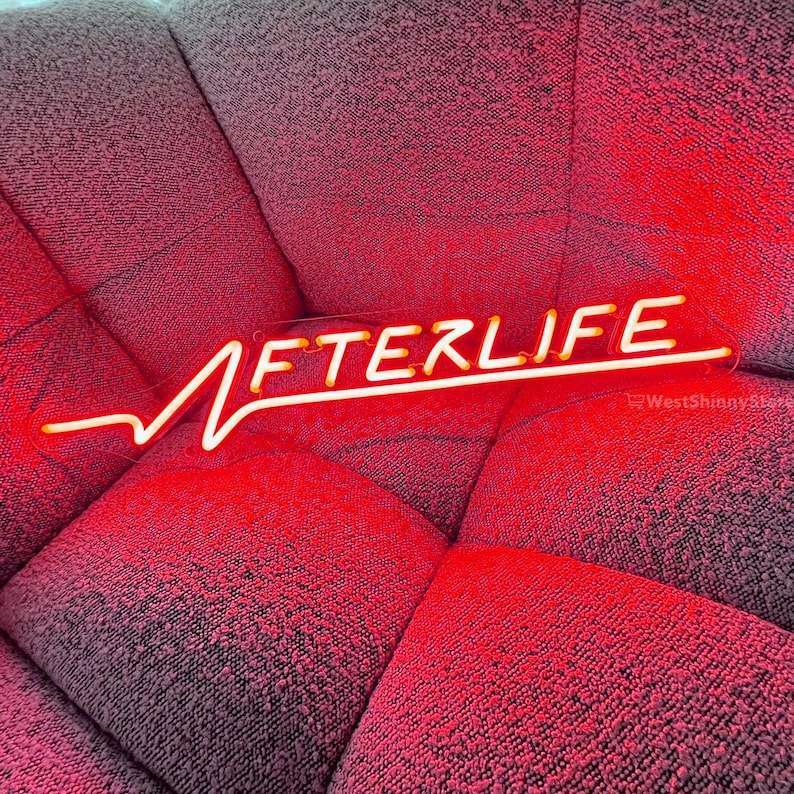Op de afbeelding: Een neonbord met het woord "AFTERLIFE" in witte letters op een rode achtergrond. Het bord is gevormd als een hartslag.