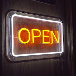 May include: A white neon sign with a yellow neon "OPEN" sign inside. The sign is mounted on a wooden door.