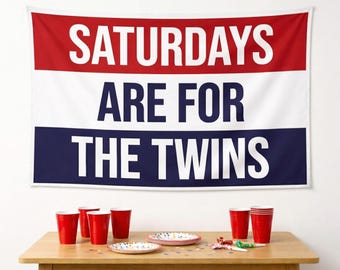 May include: A rectangular wall tapestry featuring horizontal red, white, and blue stripes with the text SATURDAYS ARE FOR THE TWINS printed in bold white and dark blue lettering across the center of the fabric banner.