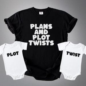May include: A black t-shirt with the text "PLANS AND PLOT TWISTS" in white, paired with two white baby onesies. One onesie says "PLOT" and the other says "TWIST" in black.