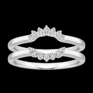 Puede incluir: Un anillo de plata con una doble fila de pequeños diamantes engastados en forma de curva. El anillo está diseñado para ser usado como un realzador de banda de boda.