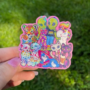 May include: A pink sticker featuring a collection of cartoon characters. The sticker includes a leopard, two aliens, a unicorn, two dalmatian dogs, a cat wearing a hat, a white cat, and a black cat. The sticker has a glittery finish.