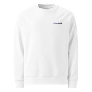 May include: A white crew neck sweatshirt with the word "KLARHAUS" printed in navy blue on the upper left chest. The sweatshirt has ribbed cuffs and a ribbed hem.