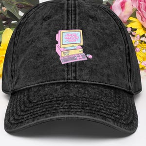 May include: Black vintage washed denim baseball cap with a pink and blue computer graphic and the text "The internet is my happy place".