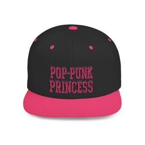May include: Black and pink snapback hat with the text "POP-PUNK PRINCESS" embroidered in pink. The hat features a flat brim and a pink button on top. A stylish accessory for any casual outfit.