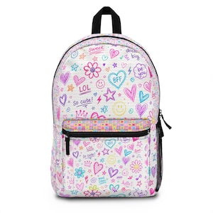 Pode incluir: Mochila branca com um design de rabisco colorido com corações, estrelas, flores e as frases "Sweet", "LOL", "So cute!", "BFF" e "be you". A mochila tem uma alça preta, um bolso frontal e um bolso lateral de malha.