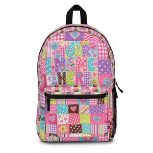 May include: A colorful patchwork backpack with a black zipper and handle. The design includes hearts, flowers, and the text "YOUR NAME HERE" in various fonts and colors. The backpack has a front pocket and adjustable straps.