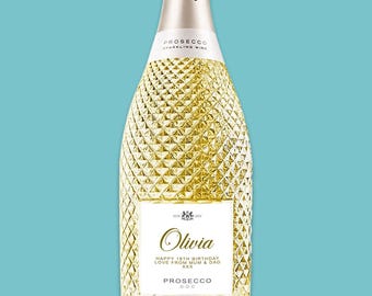 May include: A gold bottle of Prosecco sparkling wine with a white label that says "Olivia Happy 18th Birthday Love from Mum & Dad XXX Prosecco D.O.C."