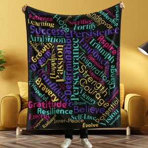 May include: A black throw blanket with a colorful word cloud design featuring words like "Hope", "Success", "Gratitude", "Resilience", "Believe", "Self-Love", and "Evolve".