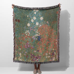 May include: A woven throw blanket featuring a colorful floral pattern with a green background. The blanket has a fringed edge and is made of a soft, comfortable material.