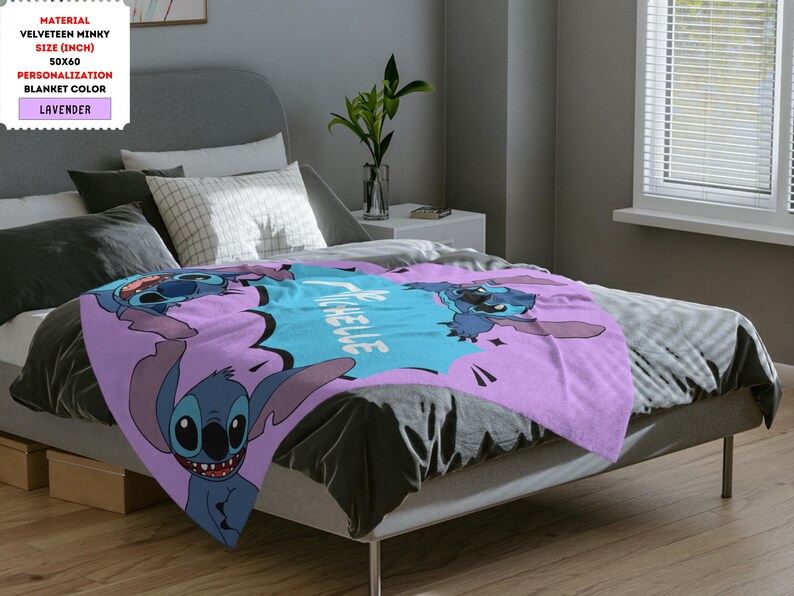 Op de afbeelding: Een lavendelkleurig pluche deken met een cartoon Stitch-personage uit de Disney-film Lilo & Stitch. Het deken heeft de tekst "Ohana betekent familie" in een blauwe spraakballon.