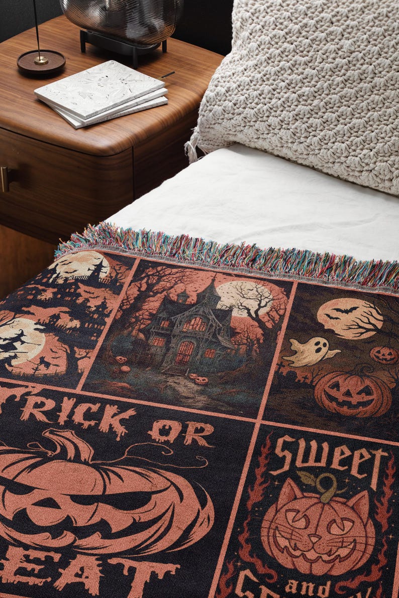 May include: A Halloween-themed throw blanket with a black background and orange and beige illustrations. The design includes haunted houses, pumpkins, bats, ghosts, and the phrases "Trick or Eat" and "Sweet and Spooky". The blanket has a fringed edge.