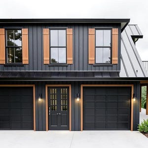 May include: A two-story, modern garage with a black exterior and natural wood accents. The garage features three black garage doors, a black front door, and wooden shutters. A balcony with stairs is visible on the side. The building is surrounded by trees.