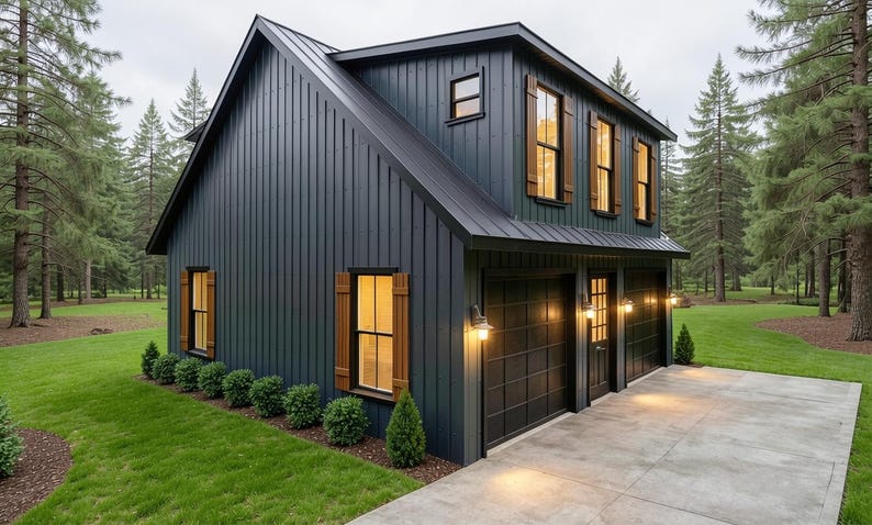 May include: A two-story, dark blue house with a black roof and wooden shutters. The house has a two-car garage and is surrounded by green grass and trees. The exterior lights are on, and the house is set in a wooded area.