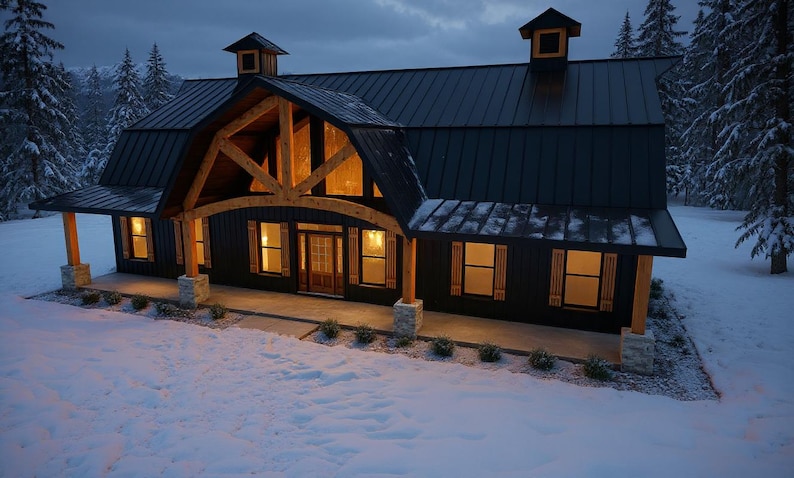 May include: A dark-sided house with a black metal roof, two cupolas, and a large timber-framed front porch entrance. The exterior features vertical siding, stone-based support columns, and warm interior lighting visible through the windows.